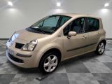 a picture of a small beige car parked in a garage