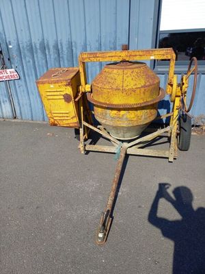 a cement mixer sitting on a cart in front of a building