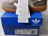 une paire de baskets adidas posée sur une boîte bleue