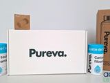 three cans of pureva on a table next to a cardboard box