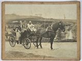 two people riding in a carriage pulled by a horse