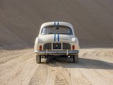 a white car driving down a dirt road in the desert