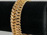 un bracelet en or posé sur un présentoir noir en forme d'anneau