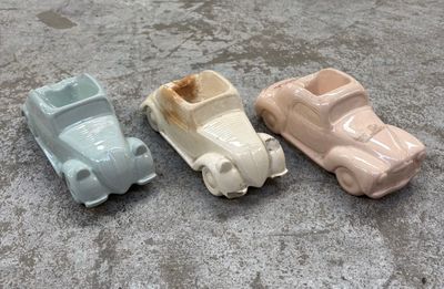 trois petites voitures qui sont posées les unes à côté des autres par terre