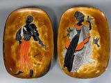these are two decorative plates with black and orange designs on them