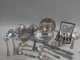 a lot of silver spoons and other silverware on a table