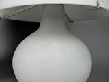 a white lamp that has a white shade on it