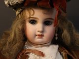 an old fashioned doll with a hat and pearls on it ' s head