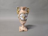 a vase that is sitting on a stand on a table