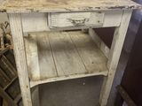 a small table with a drawer on it in a room