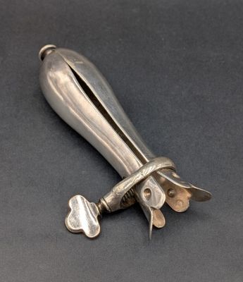 un couteau ancien en argent, avec un manche en métal sur un fond noir