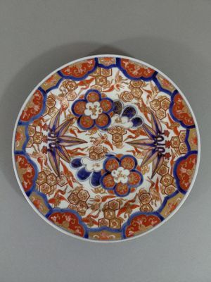 une assiette orange, bleue et blanche ornée d'un motif floral