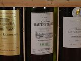 several bottles of wine are lined up in a row on a shelf