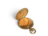 a small gold pocket watch on a white surface