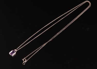 un collier en amethorate avec une chaîne sur fond noir