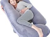 une femme enceinte allongée sur un grand oreiller gonflable pour le corps, sur un fond blanc