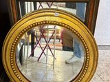 un miroir posé sur le sol à côté d'une chaise