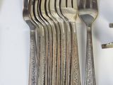 a lot of forks and spoons that are on the table