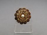 a close up of a gold ring with pearls on it