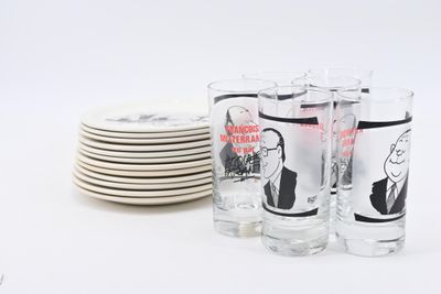 a stack of plates and glasses with a picture of a man on them