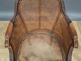 an old wicker chair on a wooden floor with a blue wall in the background