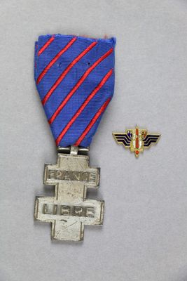 une médaille d'argent accompagnée d'un ruban bleu et rouge et d'un petit insigne