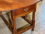 a wooden table with a drawer underneath it on a tile floor