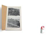 an open book with a picture of a city on it