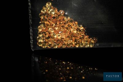 un sac rempli de perles dorées posé sur une table