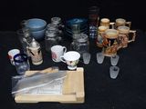 une table sur laquelle sont posés des tasses, des mugs et d'autres objets