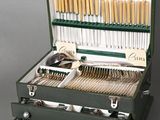 a green case with silverware in it on a gray surface