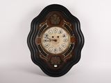 une horloge accrochée au mur devant un fond blanc