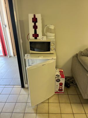 a small refrigerator in the corner of a room next to a couch