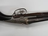 an old gun with a wooden handle on a white surface