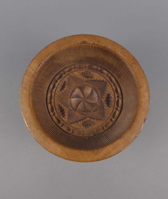 une image représentant une assiette en bois ornée d'un motif