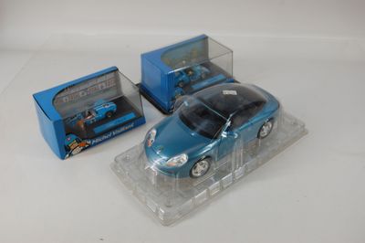 une petite voiture bleue et une boîte bleue posées sur une surface blanche