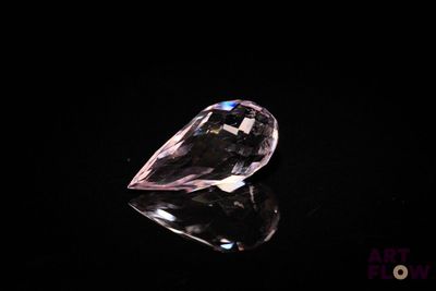 a close up of a pink diamond on a black surface