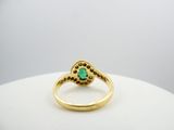 an image of a gold ring with a green stone in the center