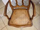 a wooden chair with a woven seat on a tile floor