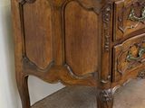 a small wooden chest of drawers on the floor