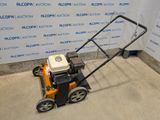 a close up of a small lawn mower on a concrete floor