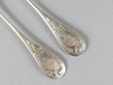 pair of silverware spoons on a table with a white background