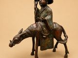 bronze statue of a man riding a horse with a hat on his head