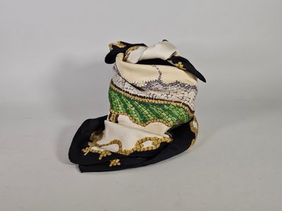 chapeau haut-de-forme blanc orné de bordures vertes et dorées et d'un nœud