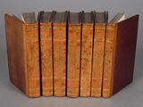 several old books are stacked on top of each other on a table