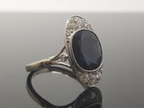 an image of a diamond and sapphire ring on a black surface