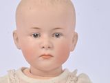 a small doll that is sitting on a white surface
