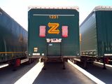 two green semi trailers parked next to each other