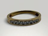 a gold ring with black diamonds on a white background
