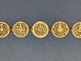 a row of gold plated oval charms on a blue surface